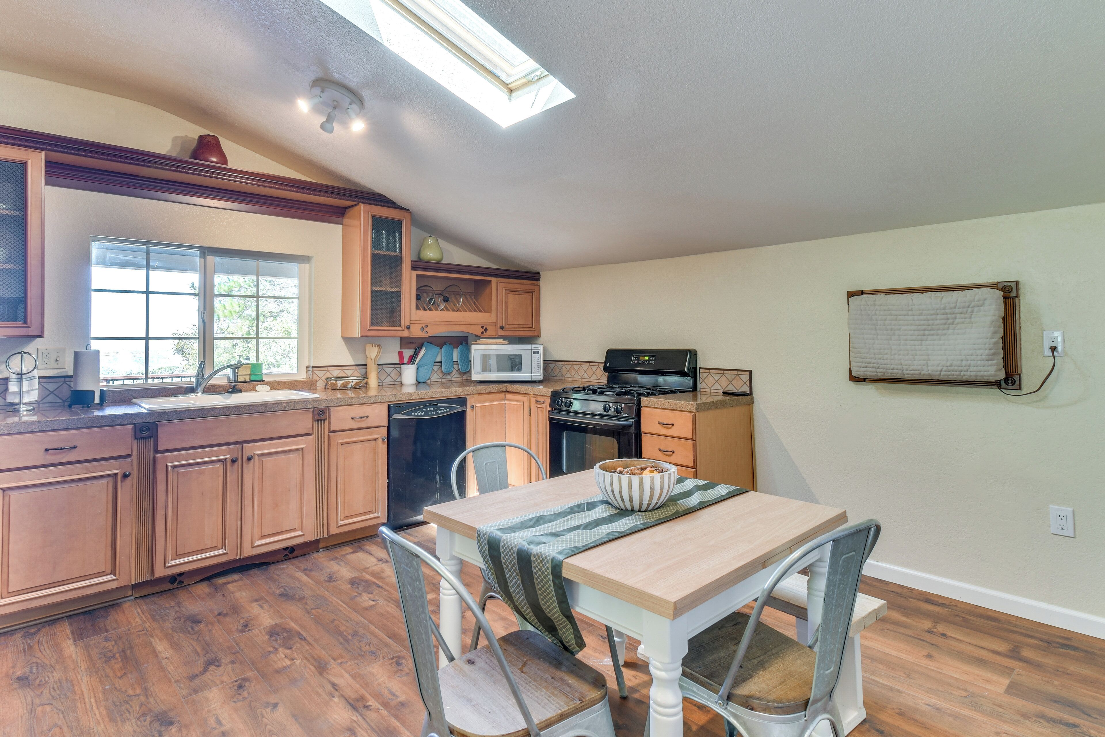 A kitchen with wooden cabinets, a microwave, stove, and a dining table with chairs.