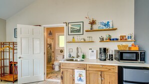 A compact kitchen with wooden cabinets, a microwave, a refrigerator, and a sink. - Studio w/ Bay View: Beach Access! Octopus's Garden (Bremerton)