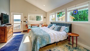 A bedroom with a bed, a television, a ceiling fan, and a view of the outside. - Studio w/ Bay View: Beach Access! Octopus's Garden (Bremerton)