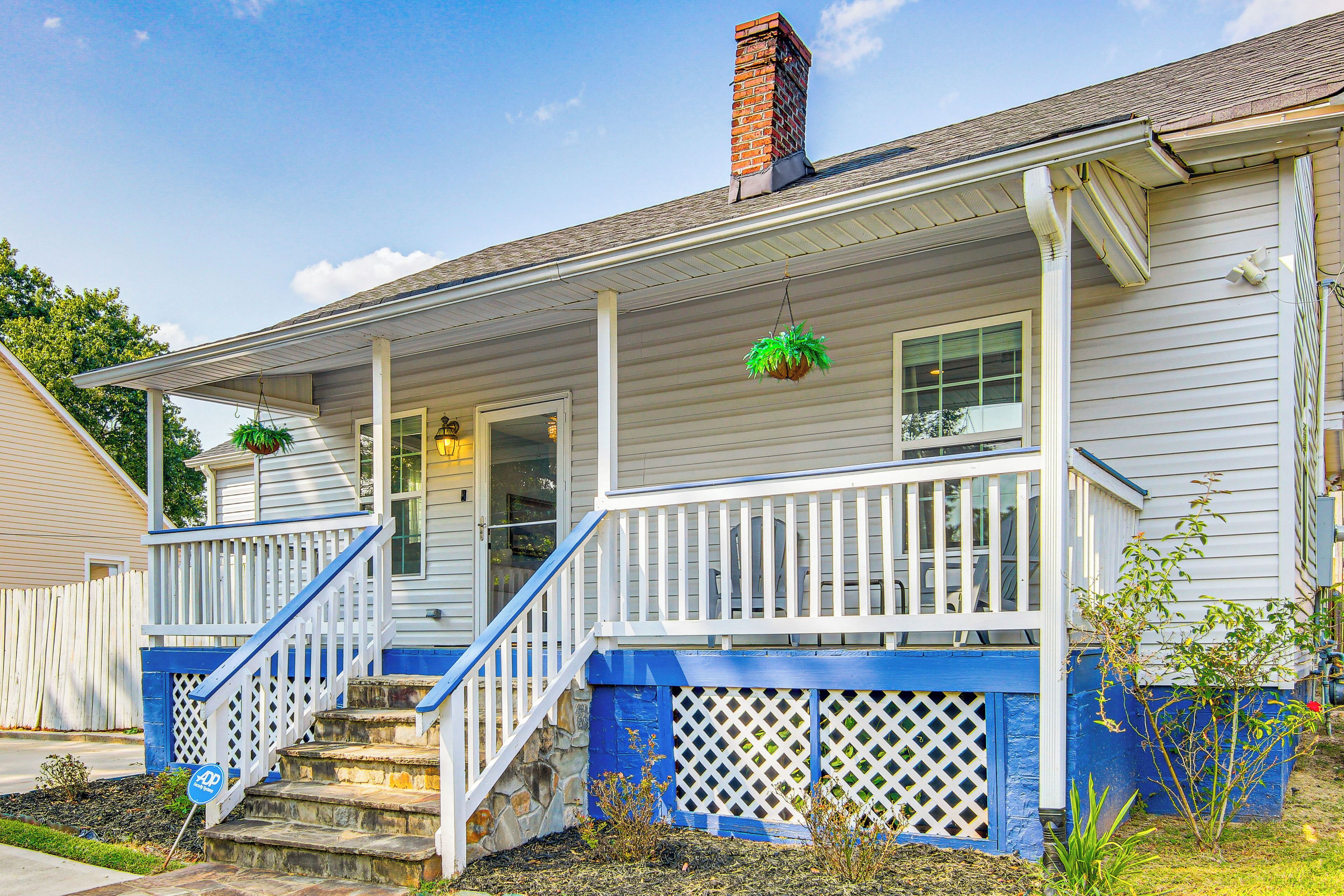 A two-story house with a porch, a brick chimney, and a staircase.