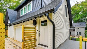 A two-story house with a garage, a wooden gate, and a deck. - 12 South Neighborhood: Home w/ Modern Flair! (Nashville)