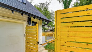 A wooden gate leading to a house with a garage, a covered porch, and a small outdoor area with steps. - 12 South Neighborhood: Home w/ Modern Flair! (Nashville)