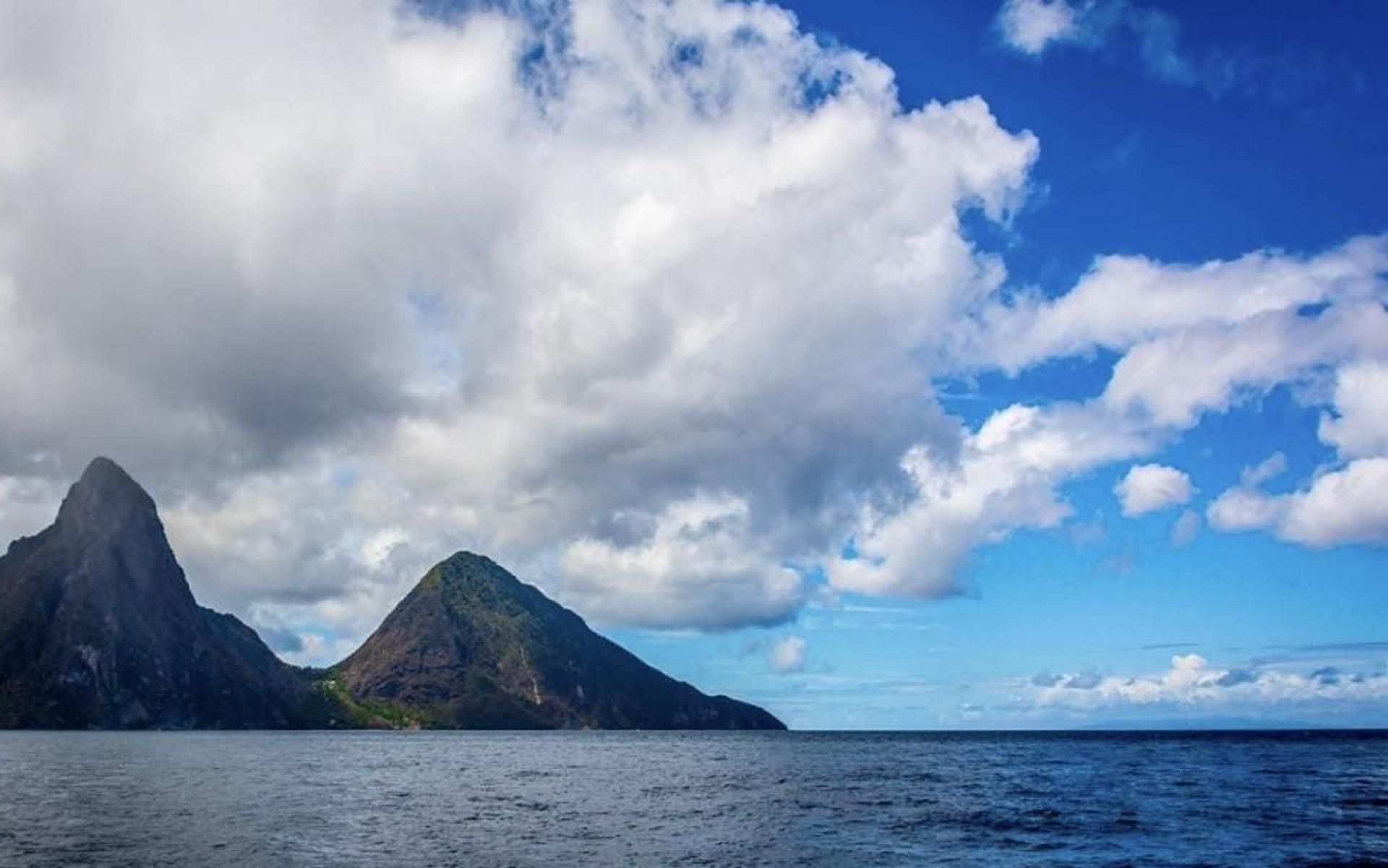 A mountainous landscape with a body of water in the foreground.