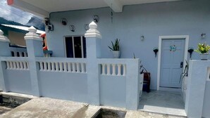A house with a white exterior, a front door, and a small porch area. - Lovely Studio Apartment in Soufriere From Claviers (Soufrière)
