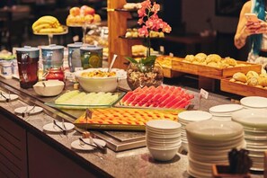 Un buffet con diversi cibi e un'orchidea decorativa.