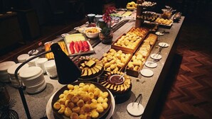 A buffet with various food items and plates. - Get a Flat 604 - Jardim Paulista  (São Paulo)