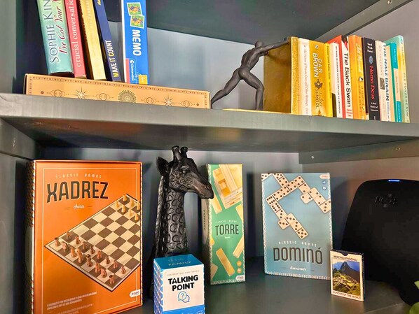 Una libreria con diversi libri e scatole di giochi.