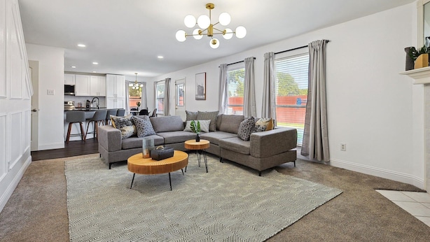 A modern living room with a sectional sofa, a coffee table, and a patterned rug.