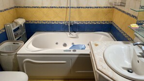 Een douche, een bubbelbad, een bidet, handdoeken