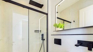 A modern bathroom with a glass shower enclosure, a white sink, and a large mirror. - Beautiful, Premium Apartment in Maida Vale (Greater London)