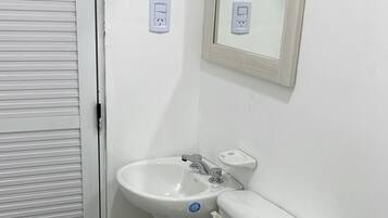 Uma casa de banho pequena com sanita, lavatório e bidé.