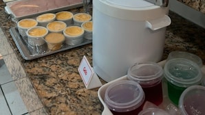 Un mostrador de buffet con diversas opciones de comida, como frutas, carnes y salsas.