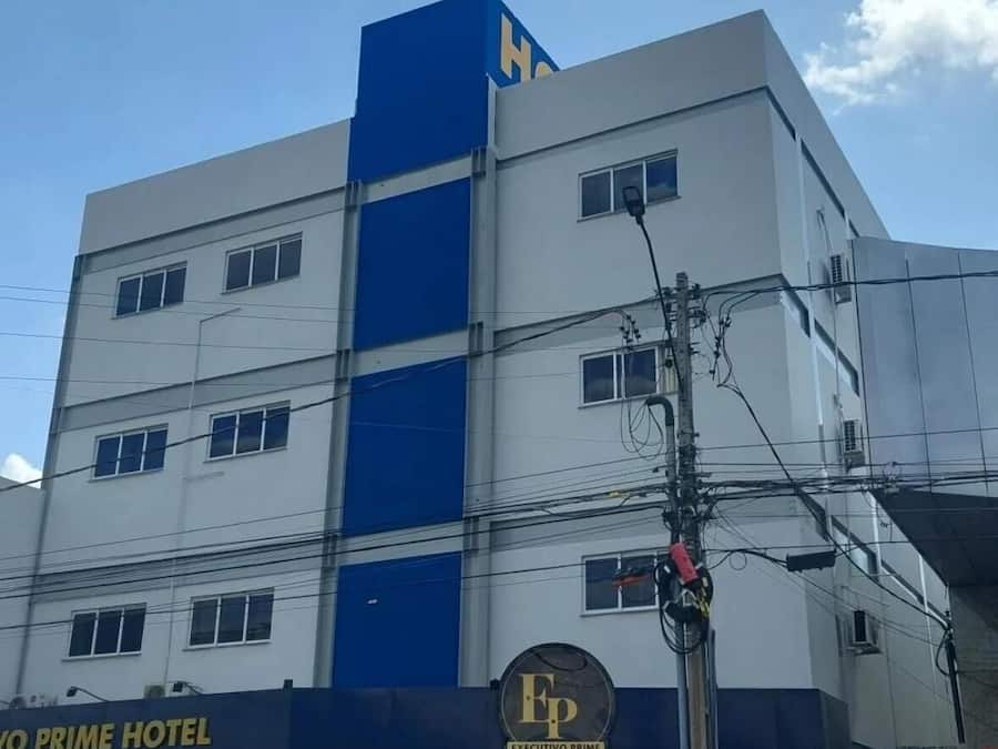 Ein mehrstöckiges Gebäude mit einer blau-weißen Fassade, einem sichtbaren Schild für "EXECUTIVO PRIME HOTEL" und zahlreichen Fenstern.