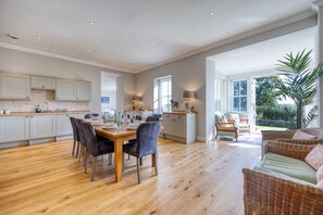 A spacious kitchen with a dining area, large windows, and a view of the outdoors.