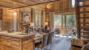 A wooden interior with a dining area, a sofa, and a bookshelf. - Chalet apartment in Megève (Megève)