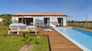 A modern house with a swimming pool, outdoor lounge chairs, and a wooden deck. - House for 7 with a pool (6 adults maximum) (Saint-Hilaire-de-Riez)