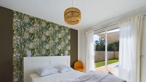 A bedroom with a bed, a chair, a window, and a view of the outdoors. - House for 7 with a pool (6 adults maximum) (Saint-Hilaire-de-Riez)