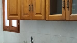 Une cuisine avec des meubles en bois, un plan de travail en granit, un évier à deux bacs et une fenêtre.
