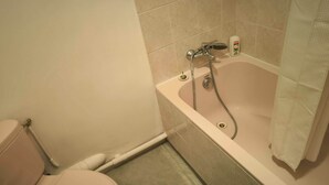 A bathroom with a toilet, a bathtub, and a shower. - Hôtel de la Gare (Périgueux)