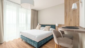 Ein modernes Hotelzimmer mit einem Bett, einem Schreibtisch und einem Stuhl.