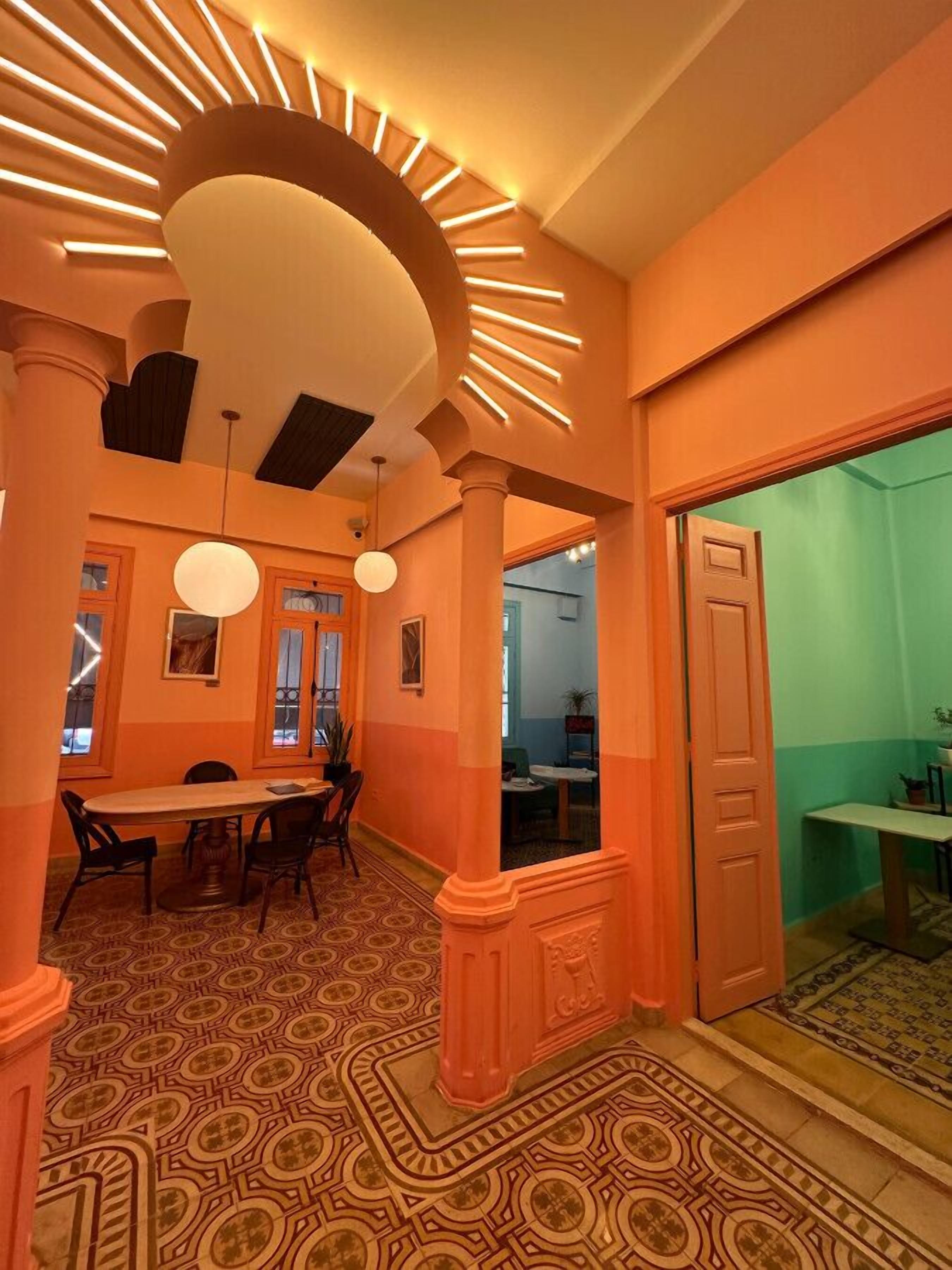 Un espace repas avec un sol à motifs, une table ronde et des chaises. On y trouve des luminaires suspendus et un plafond doté de luminaires linéaires.