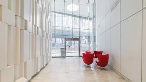 A modern hallway with a glass wall, red chairs, and a marble floor. - GLOBALSTAY. Unbeatable 53 Floor CN Tower view (Toronto/Canada)
