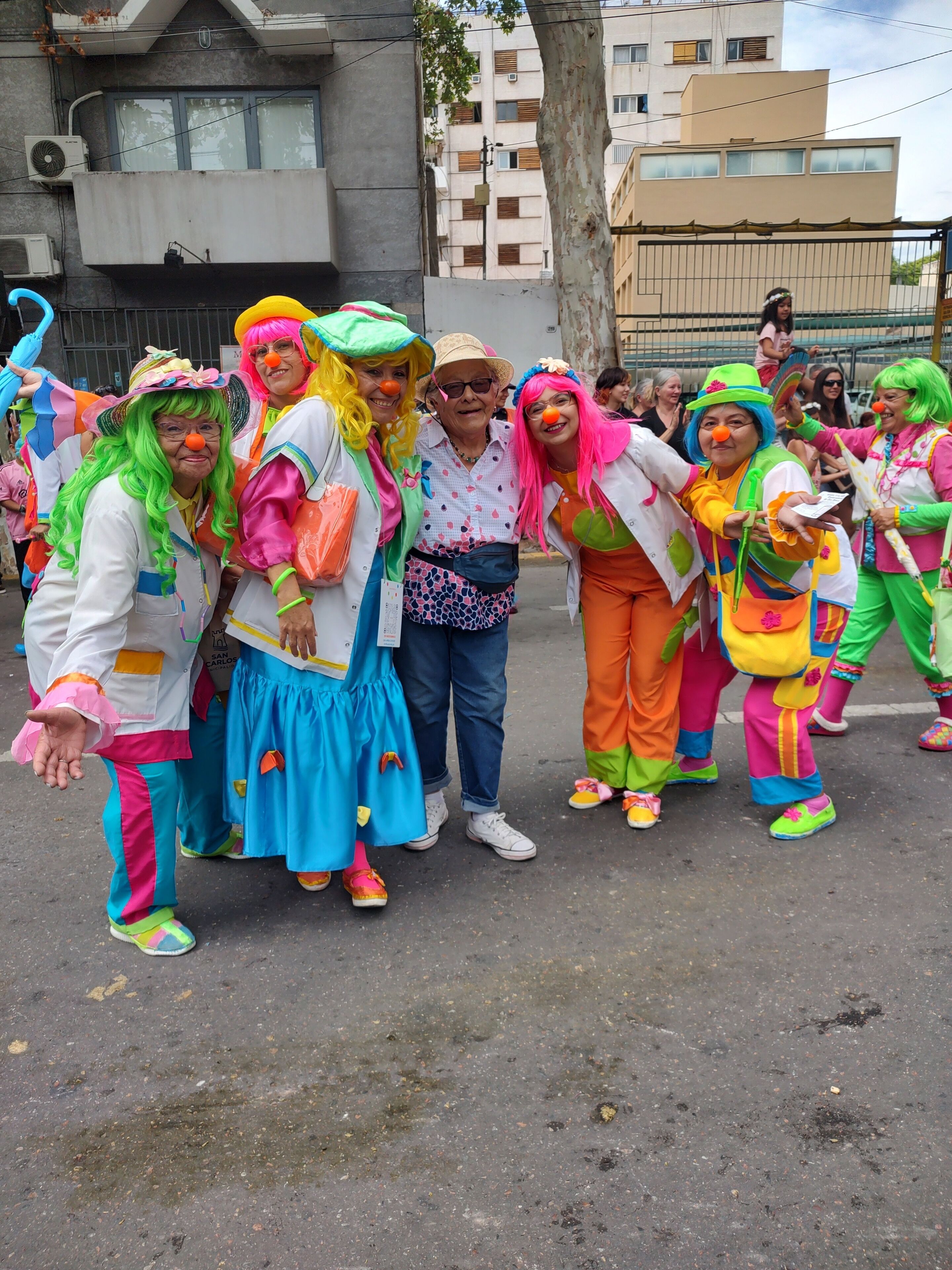 Un groupe de personnes, vêtues de costumes colorés, se tient dans la rue.