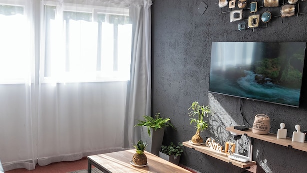 A modern living room with a dark wall, a mounted TV, and a wooden coffee table. - Plaza Independencia Mendoza Sol y Nieve  (Mendoza)