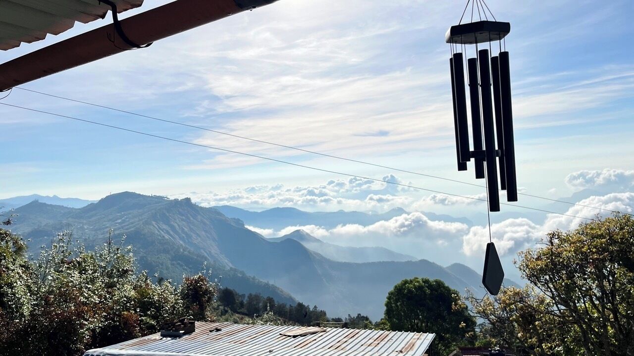 Vista de un paisaje montañoso con un móvil colgando de una estructura.