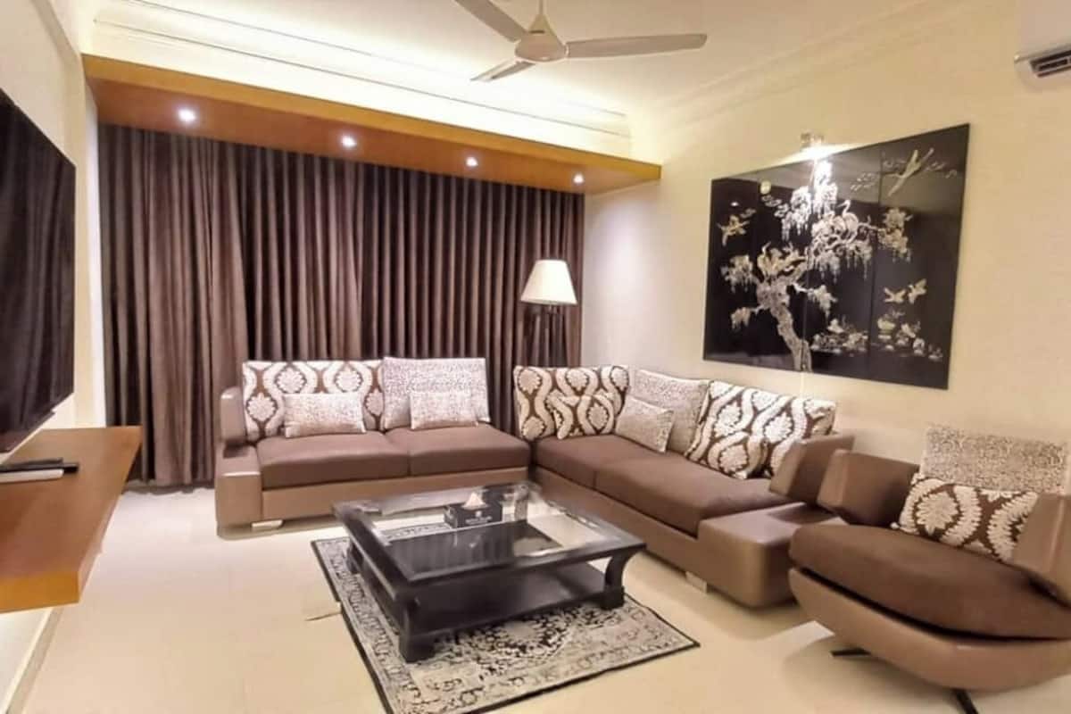 A modern living room with a sectional sofa, a coffee table, and a flat-screen TV.