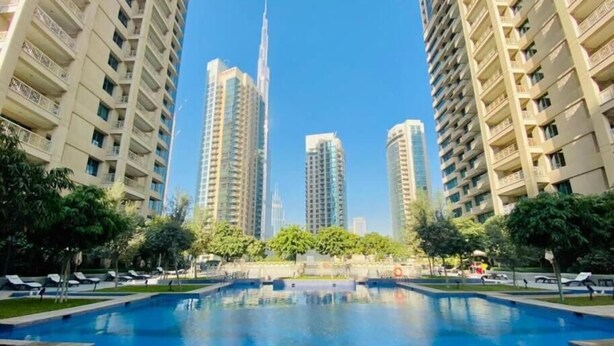 Una piscina rodeada de edificios altos con balcones.