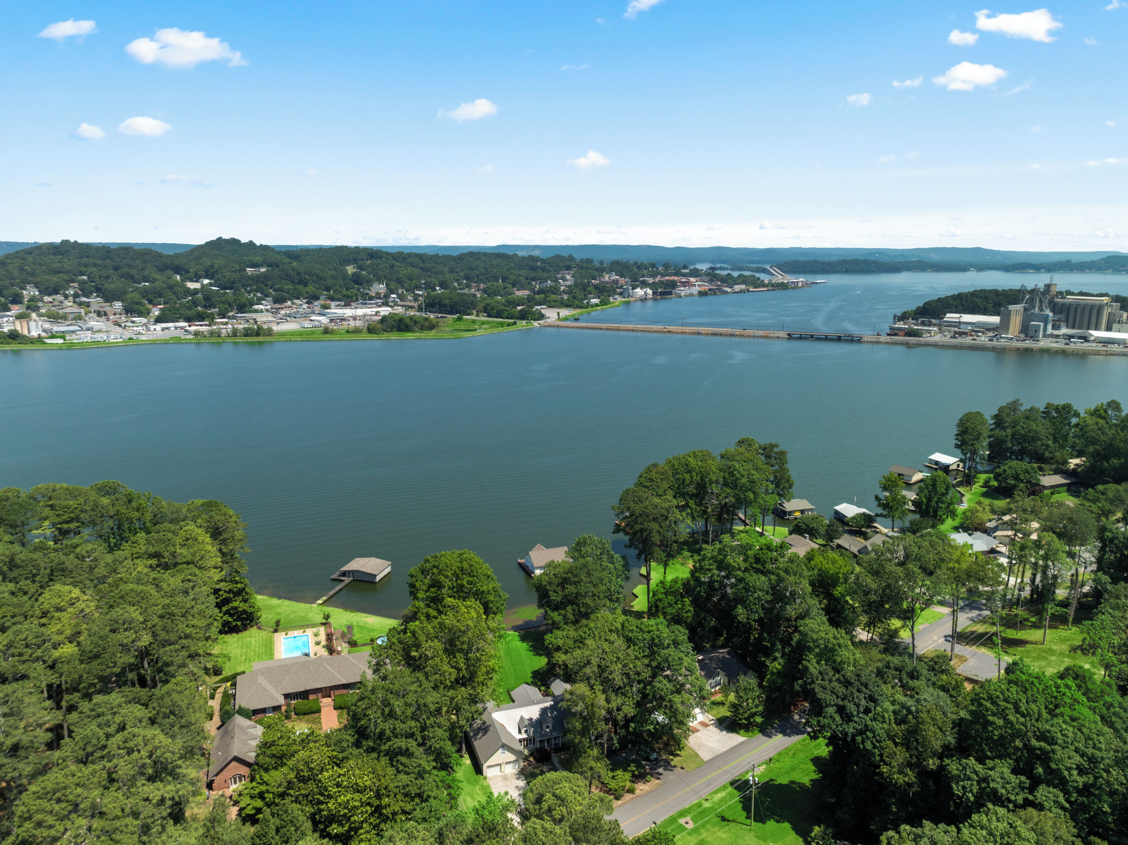 Un quartier résidentiel avec des maisons, une étendue d’eau importante et un pont en arrière-plan.