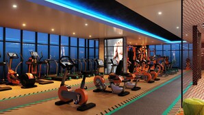 Una palestra moderna con diverse macchine cardio, attrezzature per sollevamento pesi e ampie vetrate che offrono vista sulla città.
