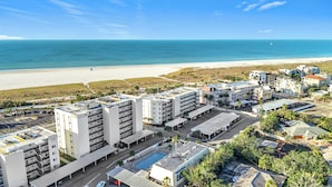 Ein Hotel an der Küste mit mehreren Gebäuden, einem Schwimmbad und Blick auf den Strand.