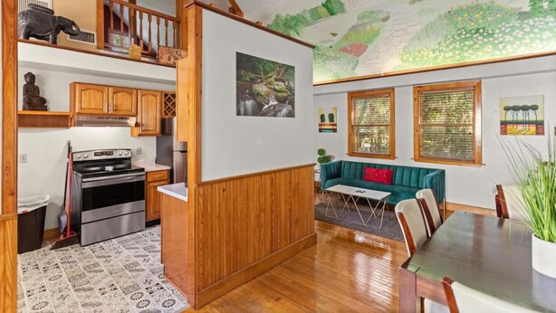 A spacious kitchen with a stove, cabinets, and a dining area with a table and chairs.