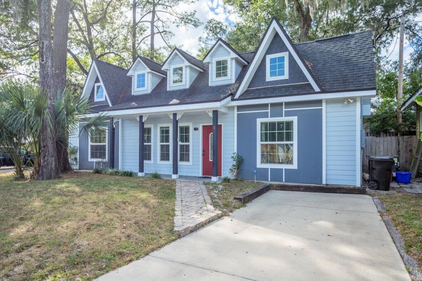 A two-story house with a front porch, a garage, and a small backyard.