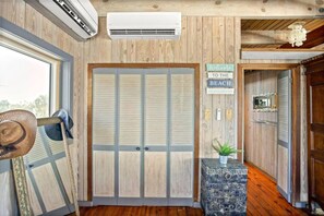 A wooden interior with a large closet, a welcome sign, and a small plant on a decorative box. - Penthouse Artist Haven Ocean front Penthouse (St. Augustine)