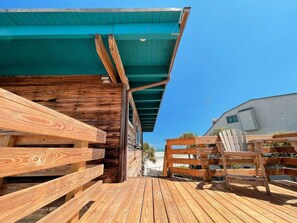 A wooden deck with a green roof, wooden railings, and a beach view. - Penthouse Artist Haven Ocean front Penthouse (St. Augustine)