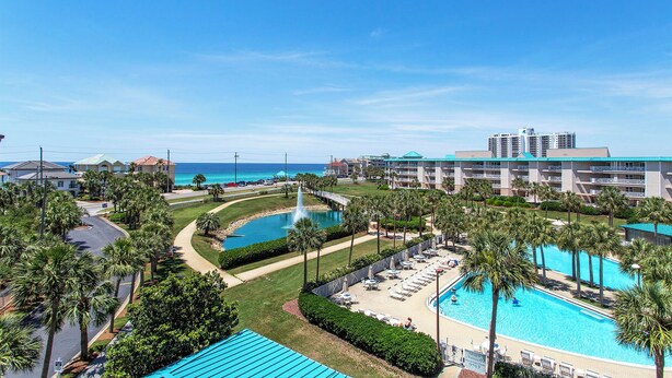 Ein Resort mit mehreren Swimmingpools, einer Brücke und Blick auf den Ozean.