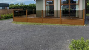 A modern building with a flat roof, large windows, and a wooden deck. - Tranquil Lodge Retreat in Wells (Wells)