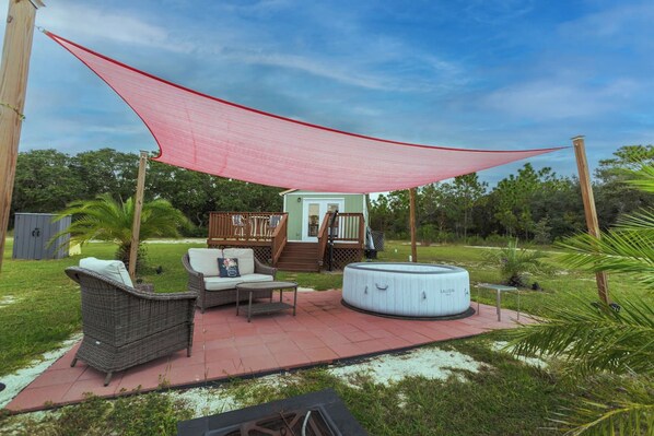 A patio area with outdoor furniture, a hot tub, and a covered deck.