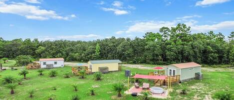 A residential area with multiple houses, a swimming pool, and a fenced yard.
