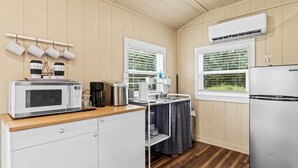 Una cocina compacta con microondas, cafetera y refrigerador.