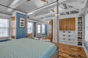 Un dormitorio con cama, armario de madera y ventana con persianas.