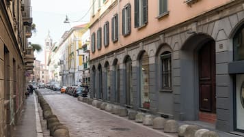 Une rue étroite bordée de bâtiments historiques, agrémentée de bornes en pierre et dotée d’un chemin piétonnier bien délimité.