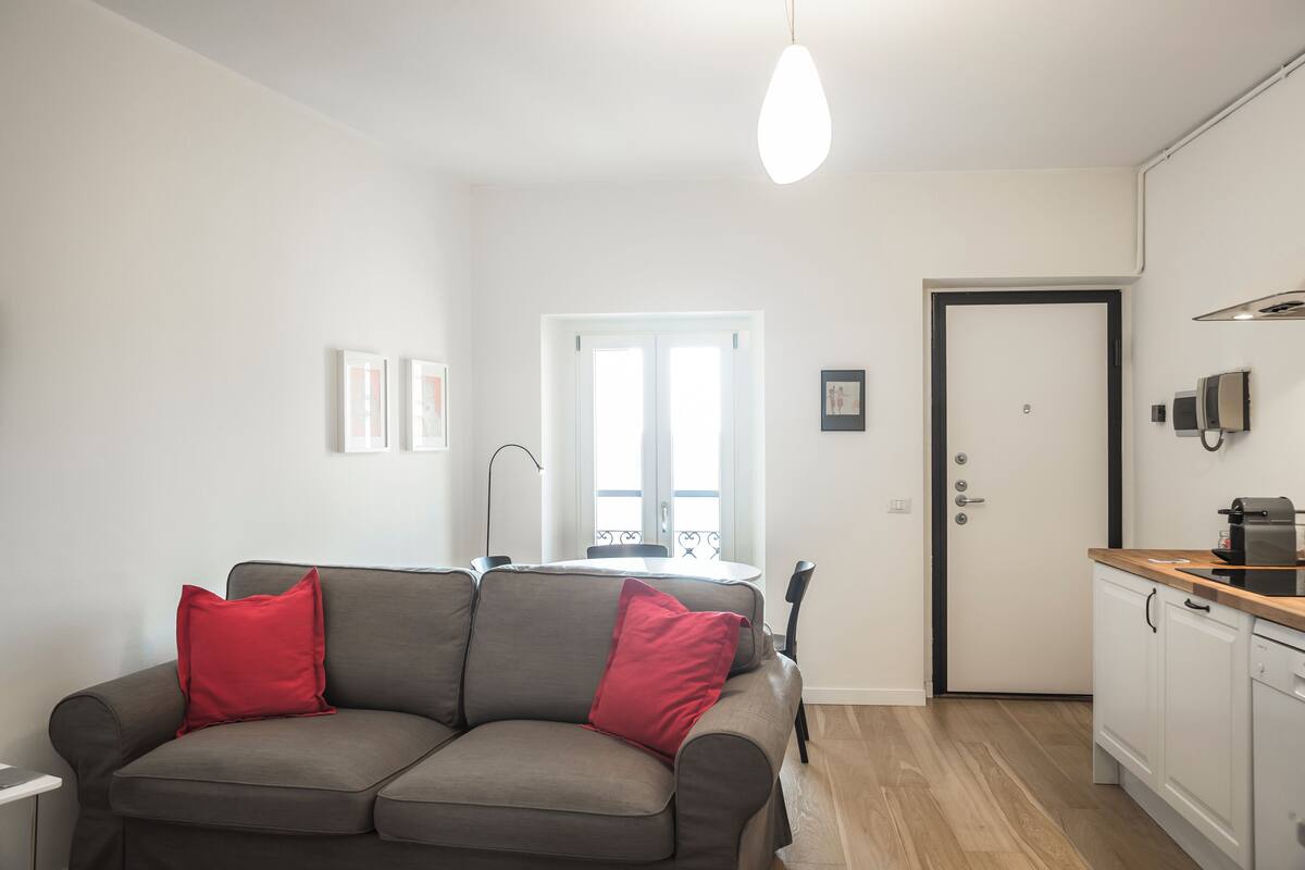 Een knus woongedeelte met een bank, een eettafel en een kitchenette.