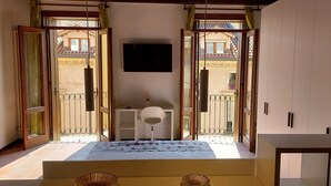 Une chambre avec un lit, un bureau et un téléviseur fixé au mur.