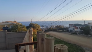 Una carretera costera con casas a un lado y el mar al otro.