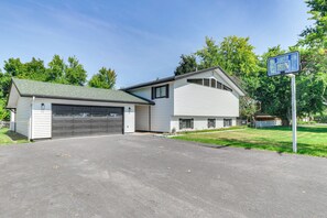 Une maison à deux étages avec un garage et un panier de basketball sur l’allée.