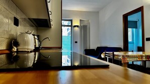 Una cucina moderna con un ampio bancone, un bollitore e una macchina da caffè. Si vede una vista sulla città attraverso una finestra.